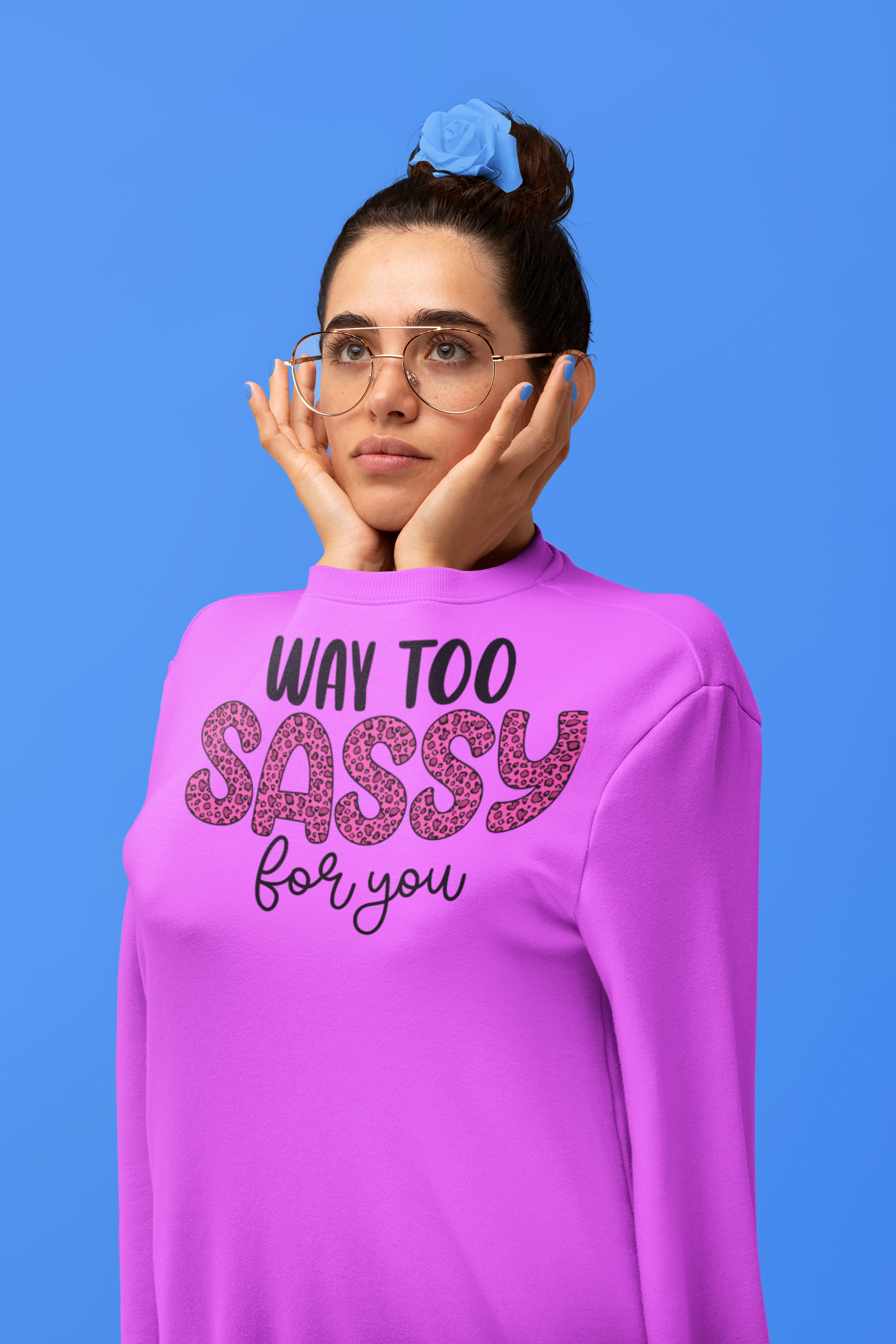 Woman wearing a pink sweatshirt with text on a blue background