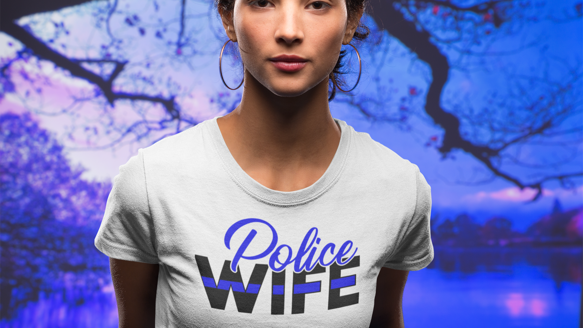 Woman wearing a 'Police Wife' t-shirt with a colorful abstract background