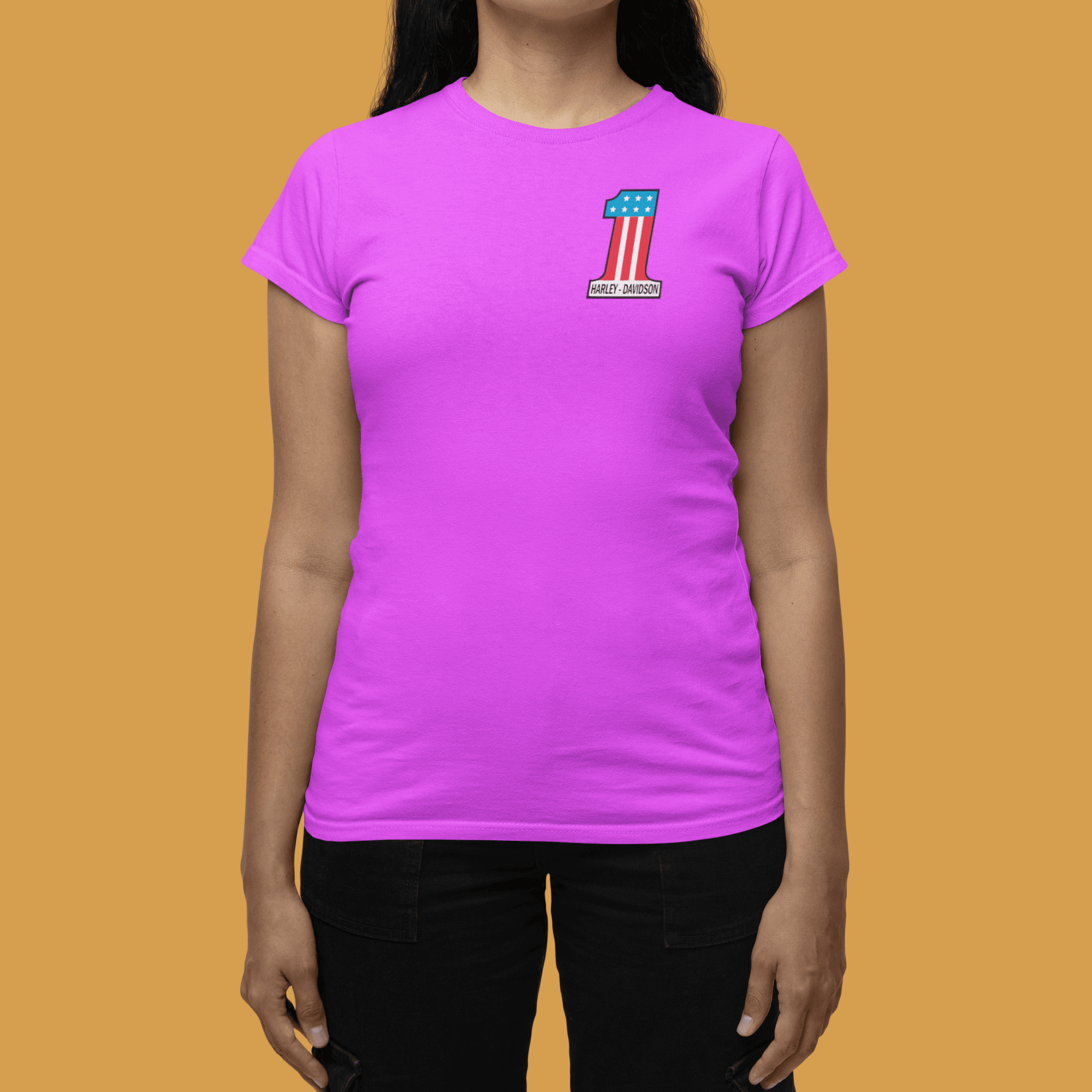 Person wearing a purple t-shirt with a small graphic on a mustard yellow background