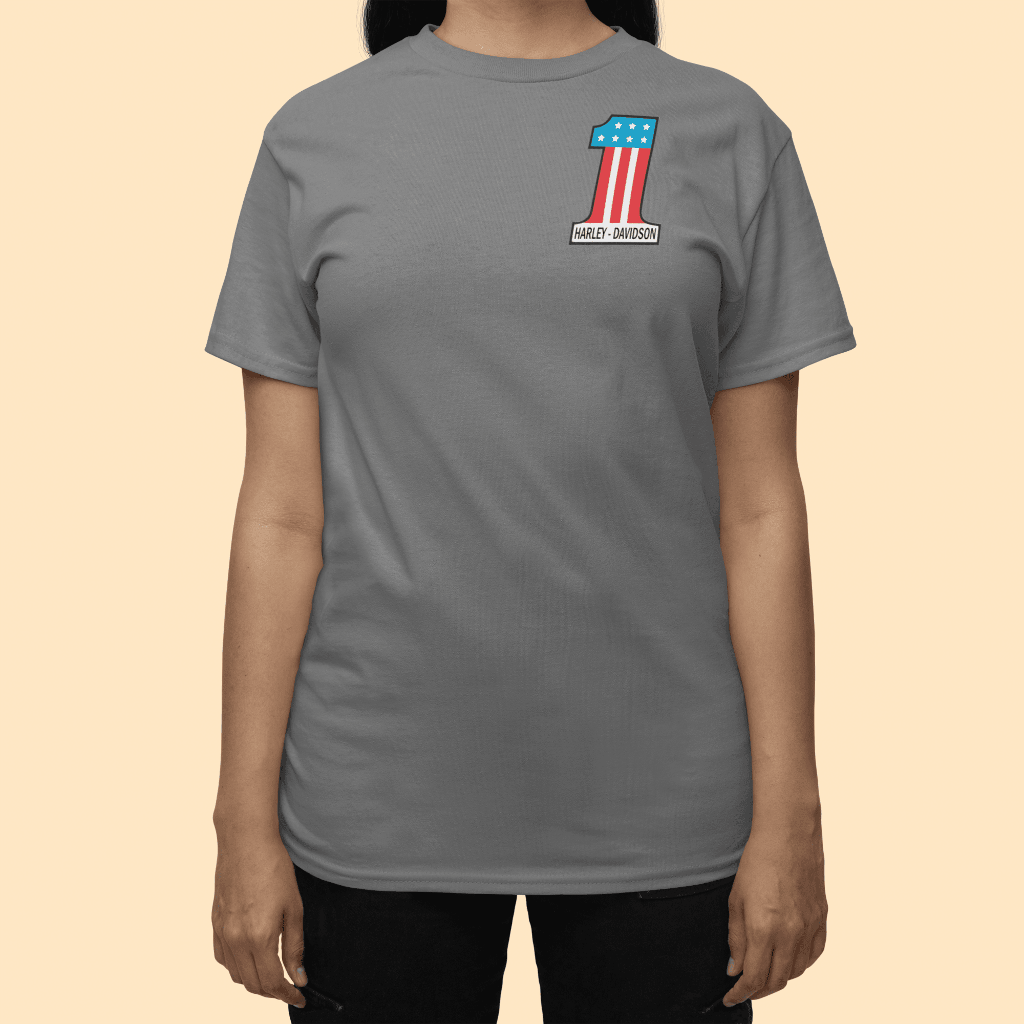 Person wearing a gray t-shirt with a logo on a beige background