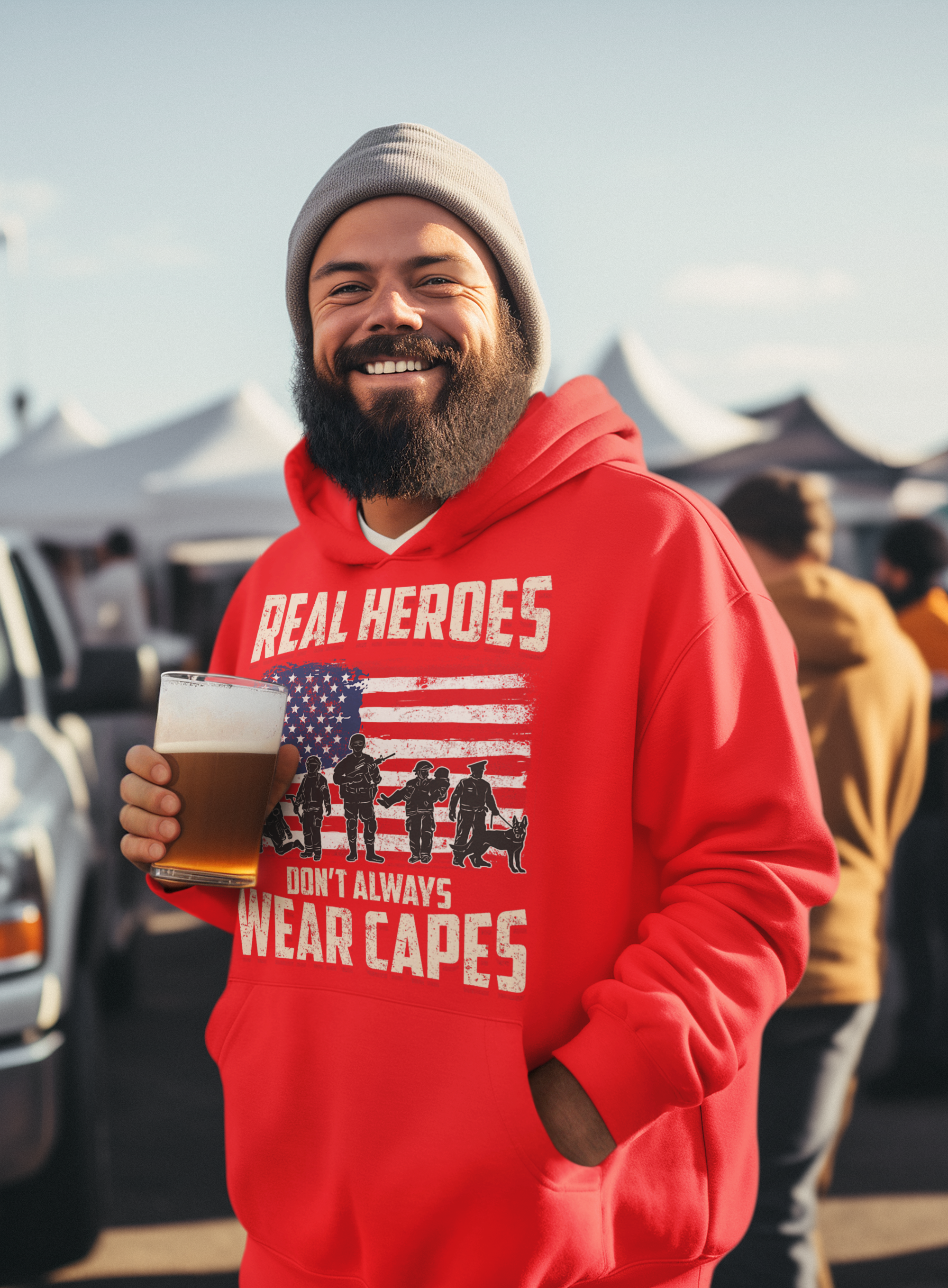 Man wearing a red hoodie with a graphic and text, holding a beer, standing outdoors.