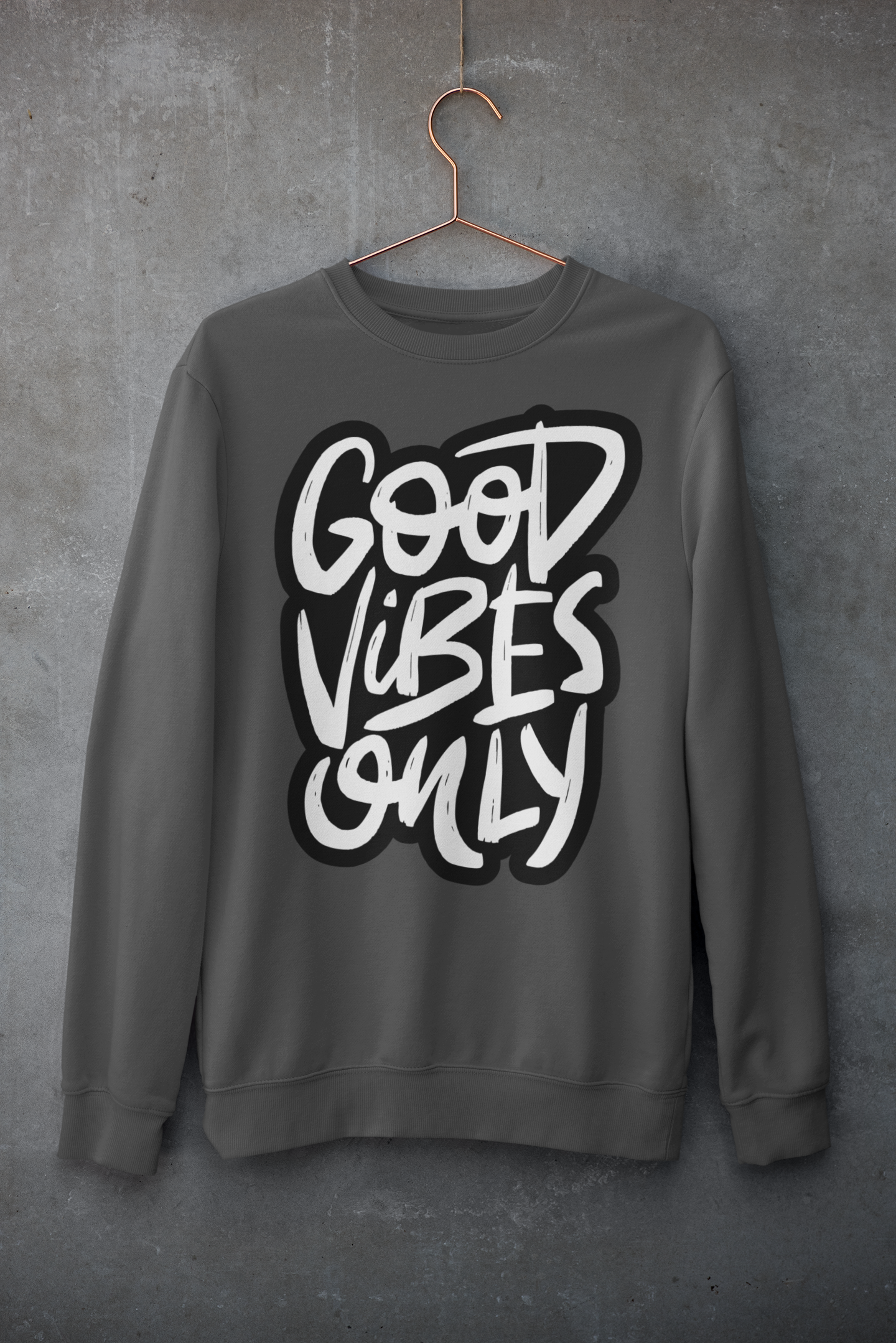Gray sweatshirt with 'Good Vibes Only' text on a hanger against a gray background