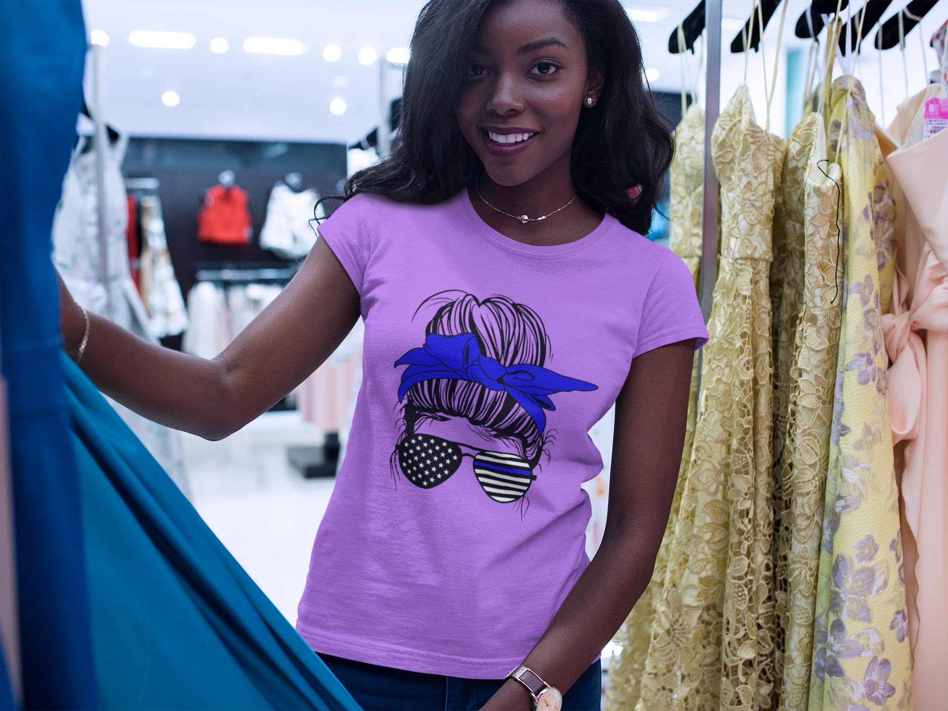 Woman wearing a purple t-shirt with a graphic design in a clothing store.