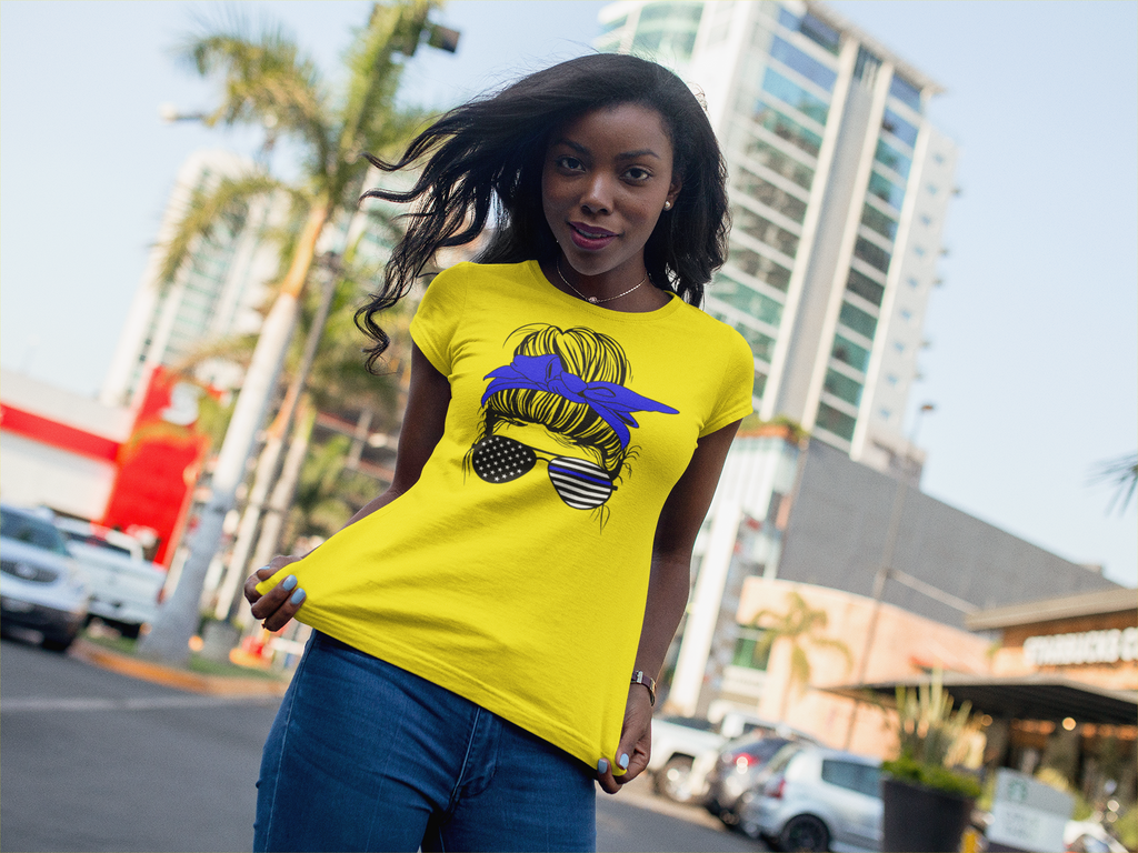 Woman wearing a yellow t-shirt with a graphic design in an urban setting
