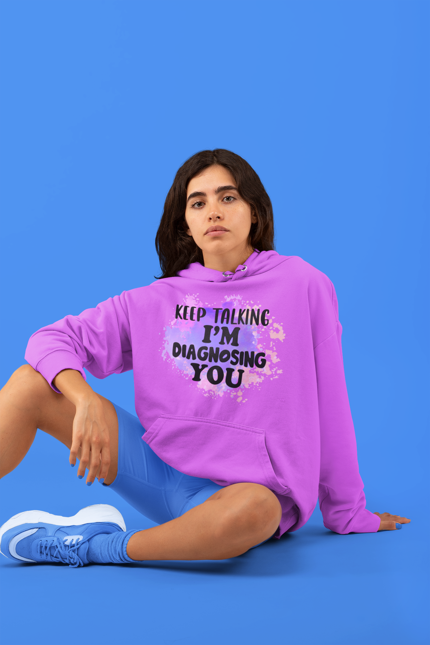 Person wearing a purple hoodie with text on a blue background