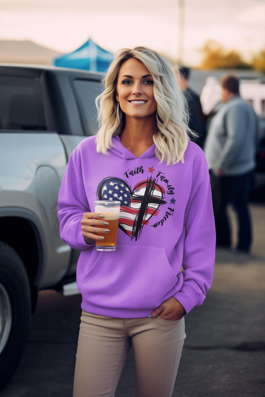 Woman wearing a purple hoodie with a graphic design, holding a drink, standing outdoors.