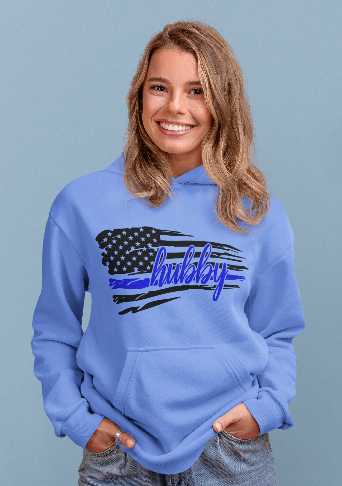 Woman wearing a light blue hoodie with an American flag design and 'hubby' text in blue 