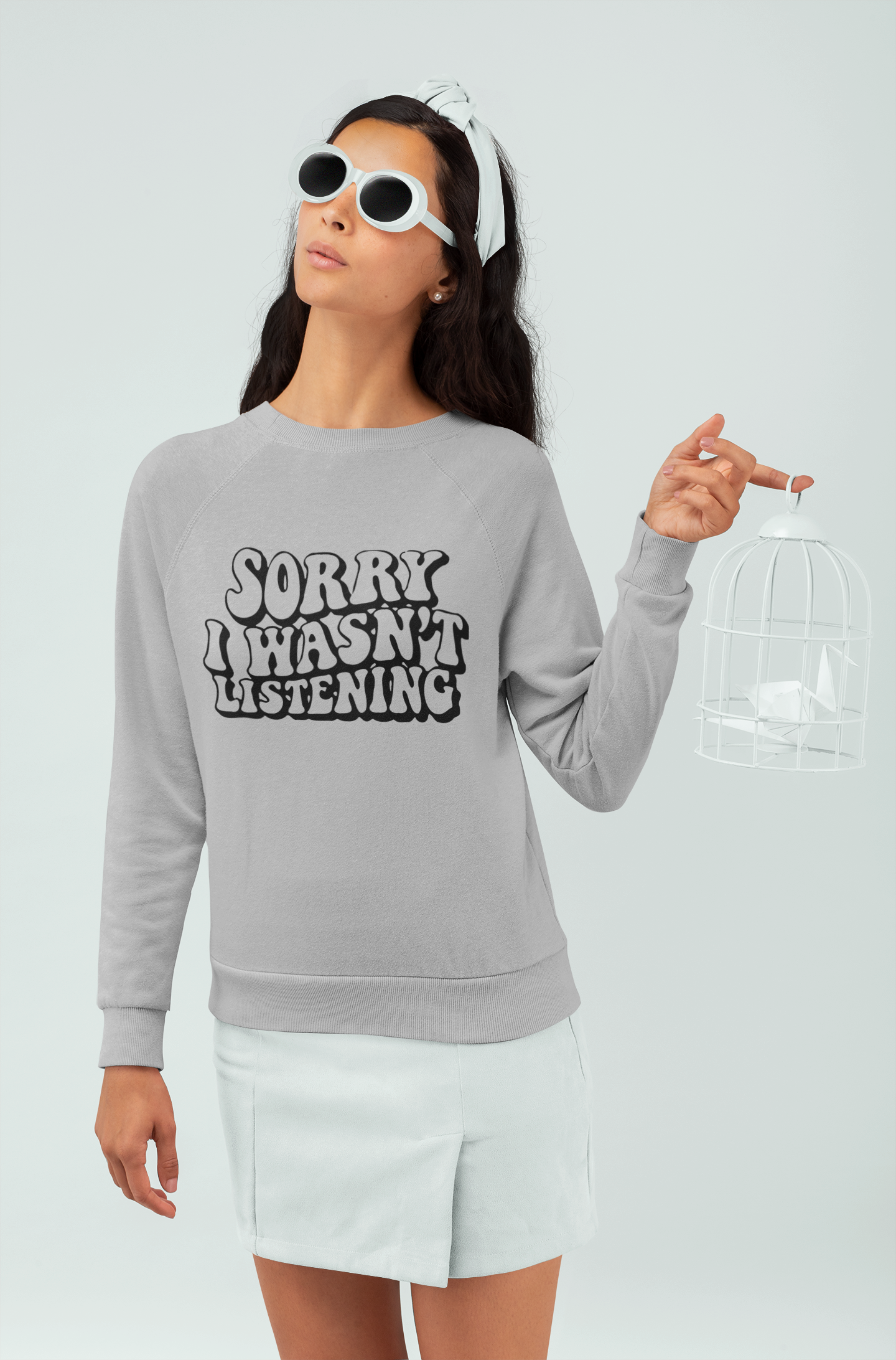 Person wearing a gray sweatshirt with 'Sorry I Haven't Listening' text on a white background