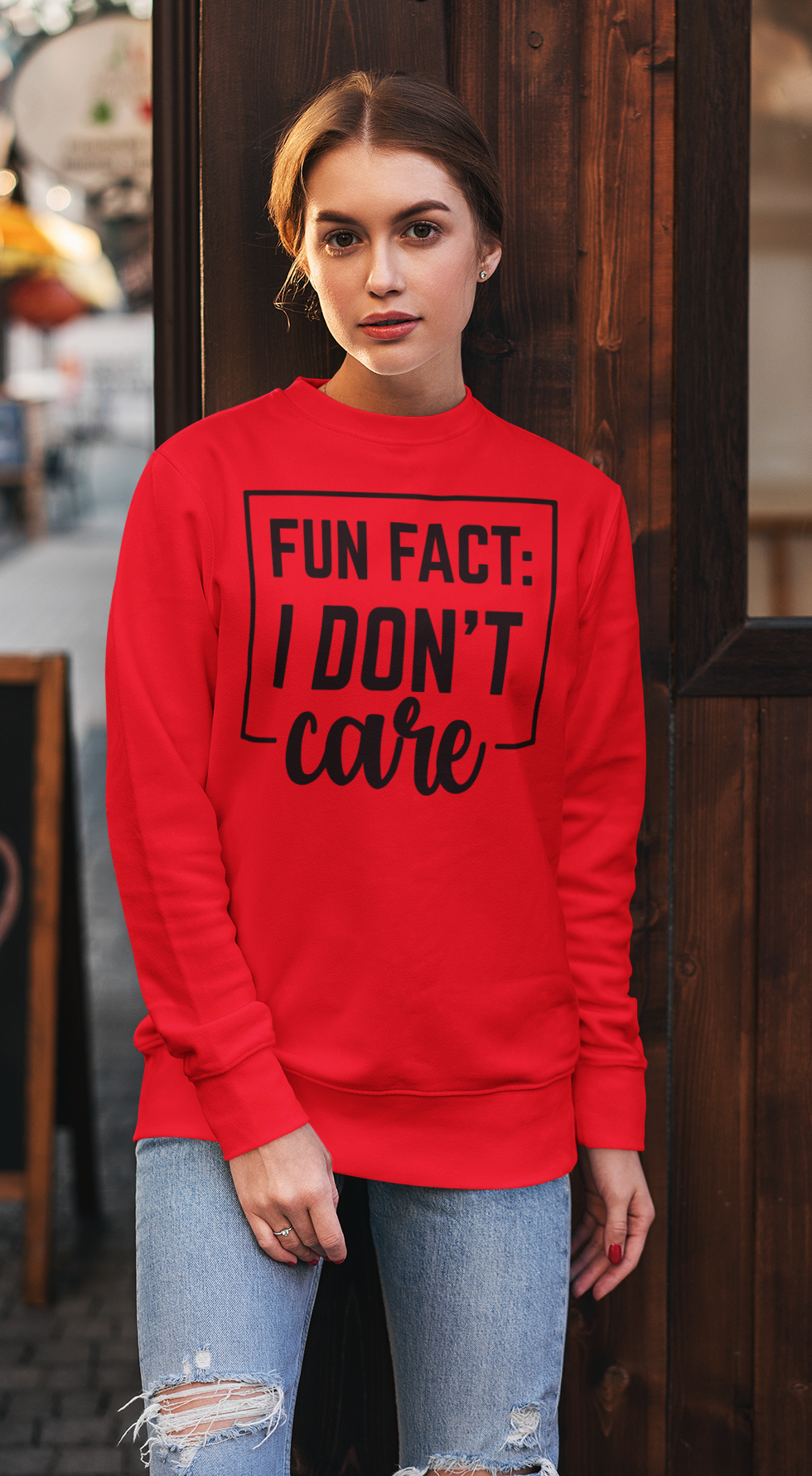 Person wearing a red sweatshirt with text in an urban setting
