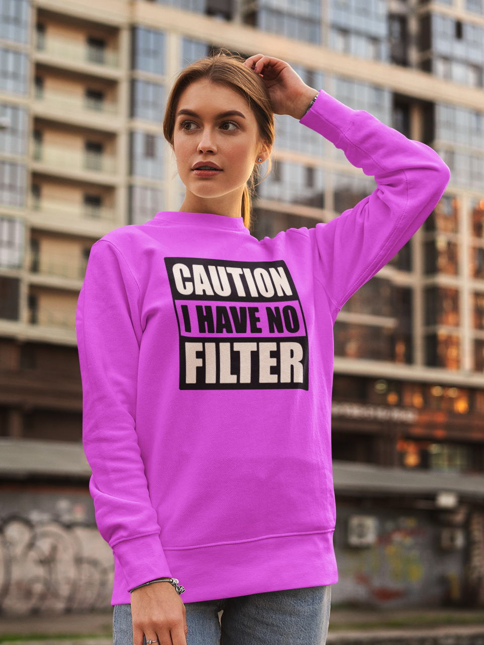 Person wearing a pink sweatshirt with text in an urban setting