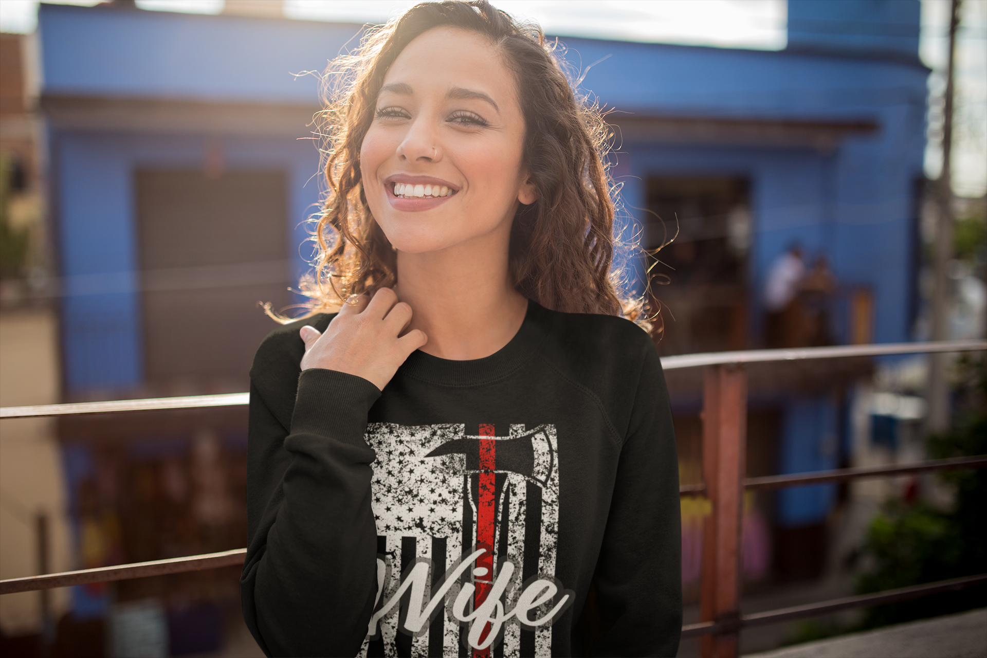 Woman wearing a black sweatshirt with a graphic design in an outdoor setting