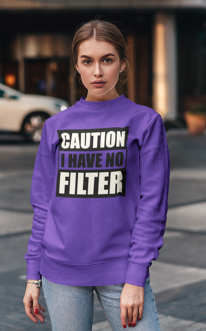 Person wearing a purple sweatshirt with 'CAUTION I HAVE NO FILTER' text outdoors.