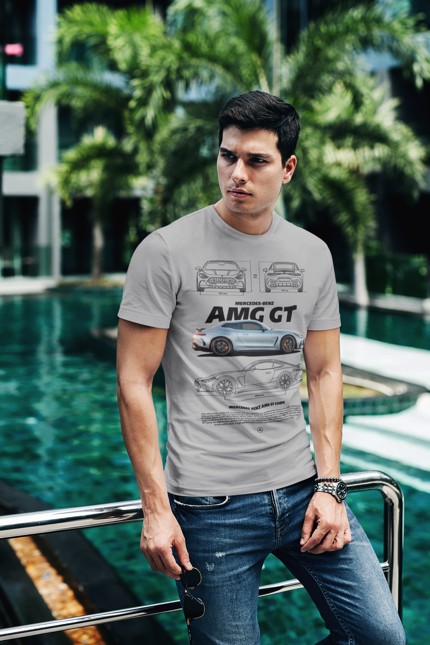 Man wearing a gray t-shirt with car design standing by a pool