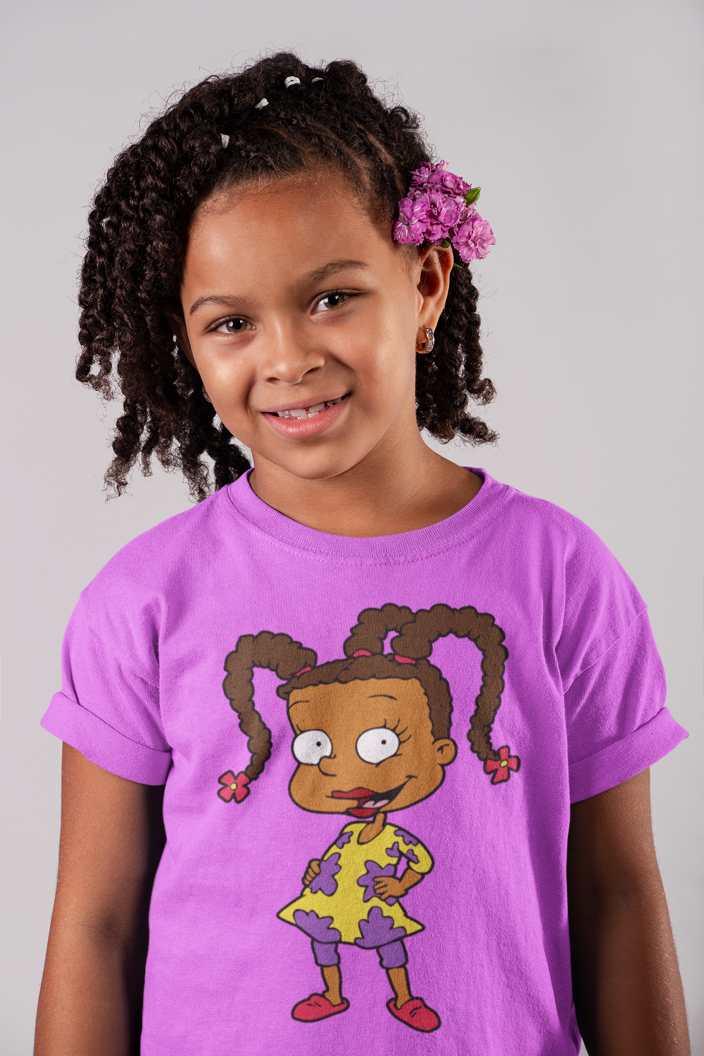 Child wearing a pink t-shirt with a cartoon character on a gray background