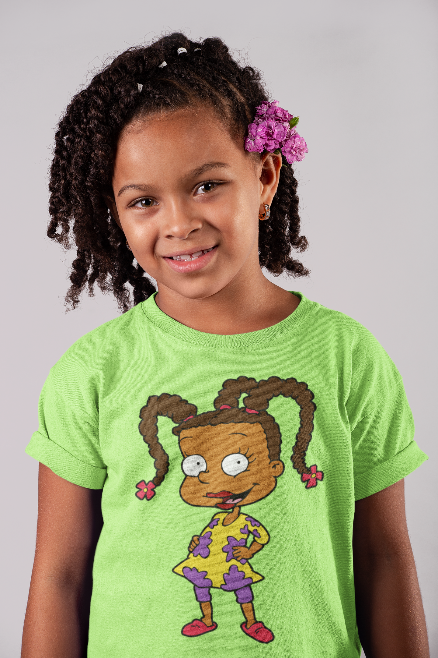 Child wearing a green t-shirt with a cartoon character on a gray background